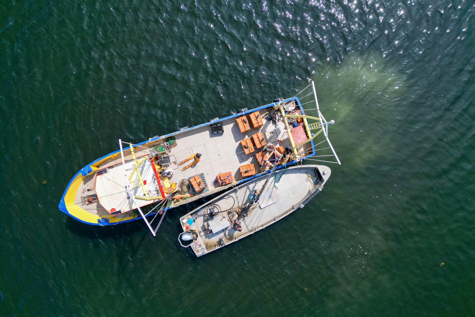 Aerial view of two workboats loaded with crates on open water during a Project Luna deployment off the North Norfolk coast